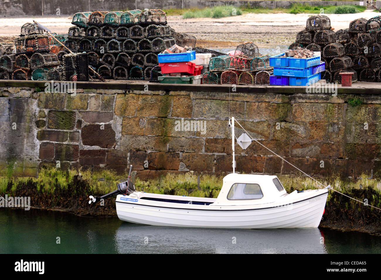 A Fishing boat and lobster pots at Seahouses harbour in Northumberland ...
