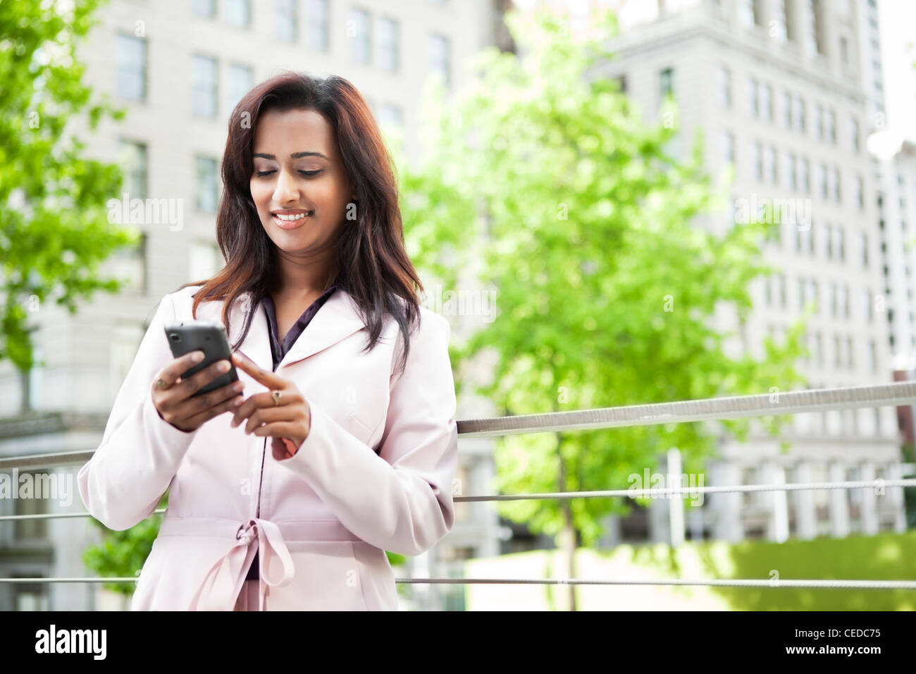 Indian businesswoman text messaging on cell phone Stock Photo - Alamy