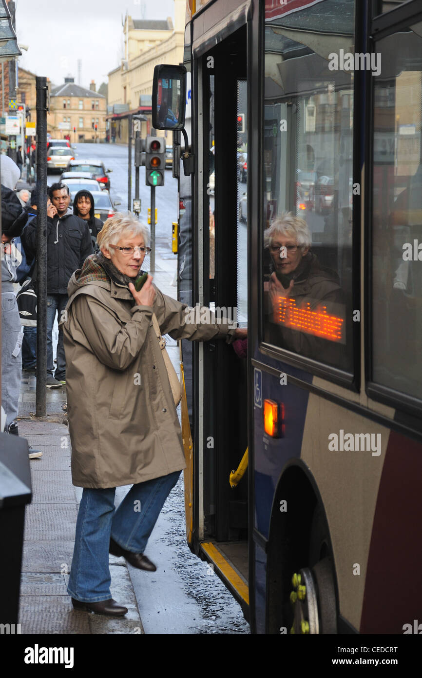 A woman gets on a bus in the centre of Glasgow Stock Photo