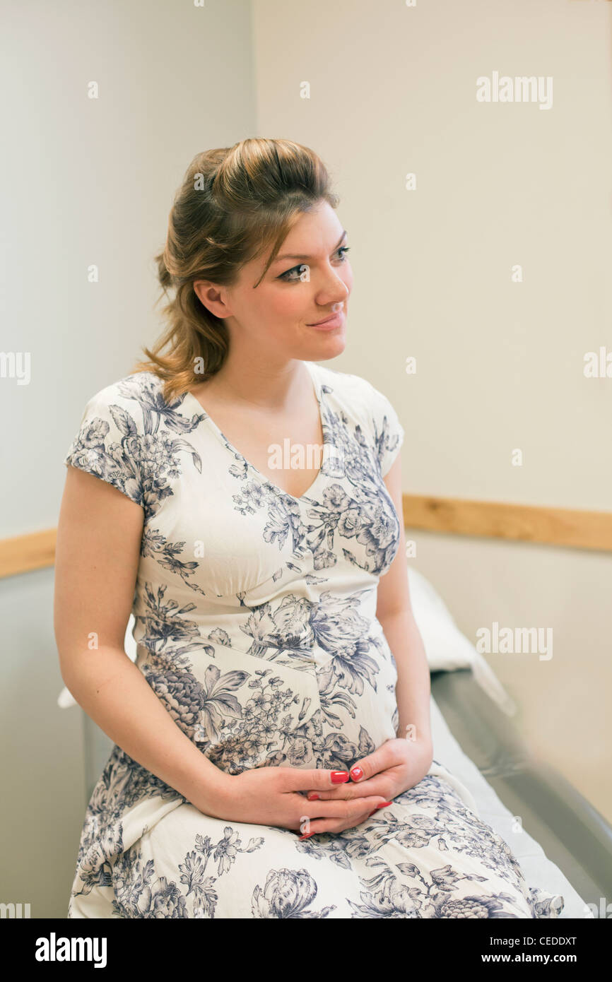 Portrait of young pregnant woman at doctors office. Stock Photo