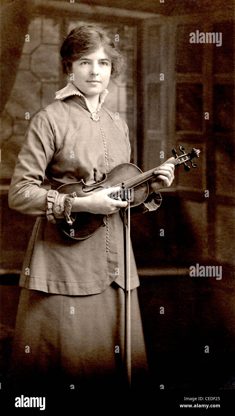 Vintage photo of a young woman posing with her violin, circa 1908. Stock Photo