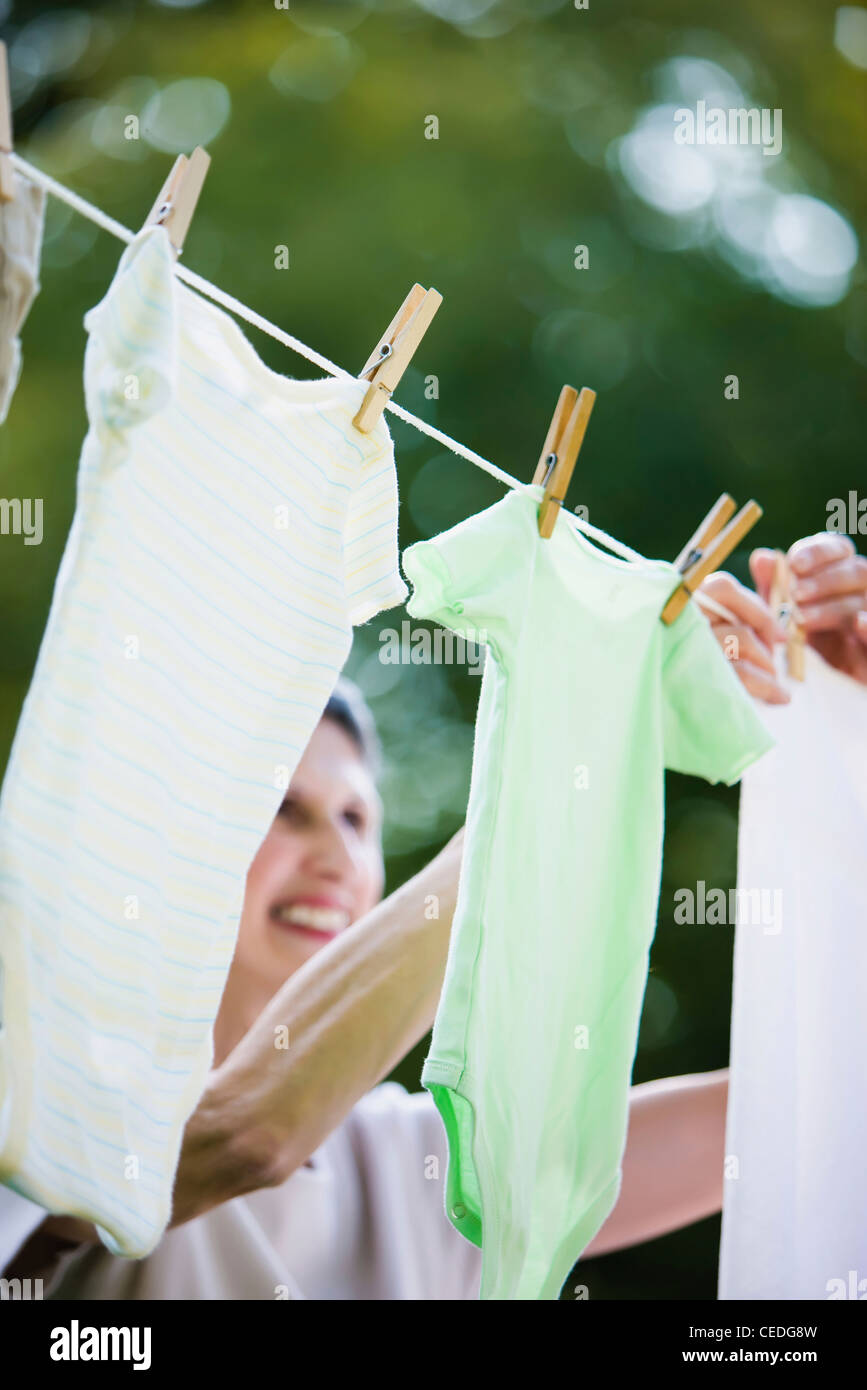 Caucasian woman hanging laundry on clothes line Stock Photo