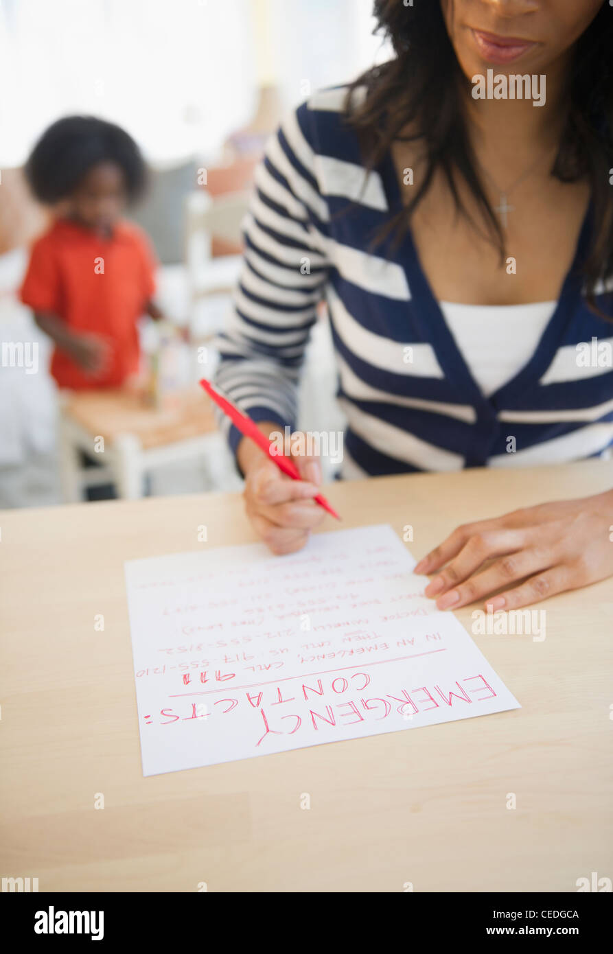 African American woman writing out contact phone numbers Stock Photo