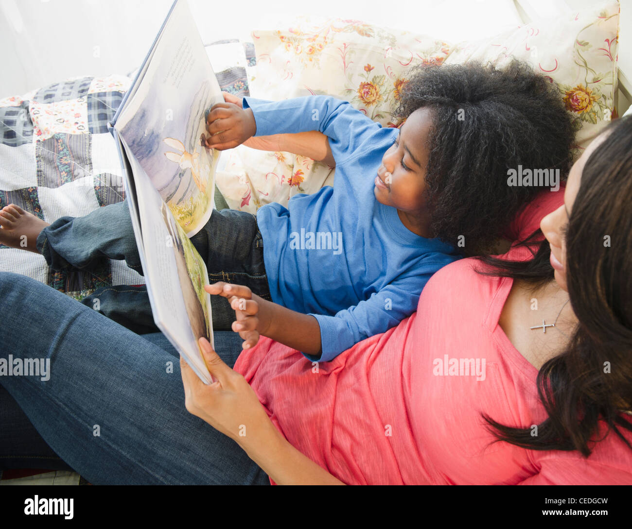 African American mother reading book to son Stock Photo