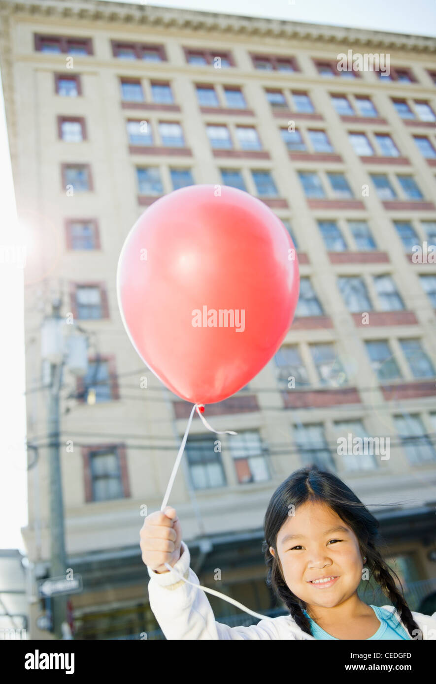 Korean girl holding red balloon outdoors Stock Photo