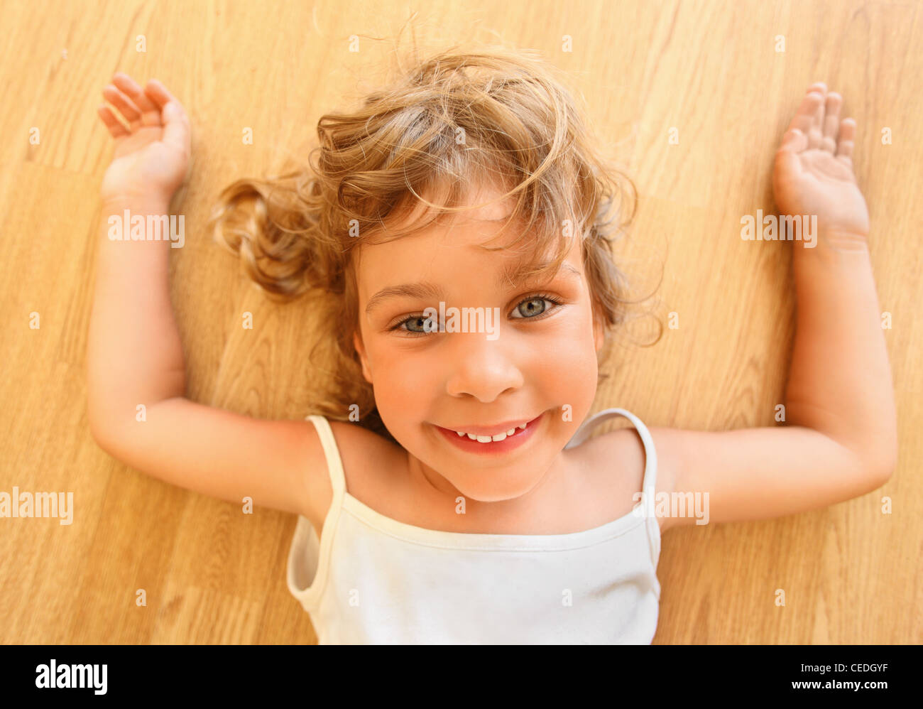 pretty smiling little girl lies on floor Stock Photo - Alamy