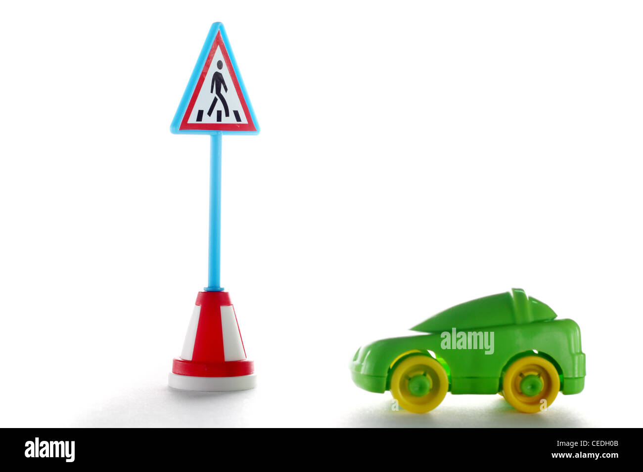 Green car behind Pedestrian crossing road sign on white background Stock Photo