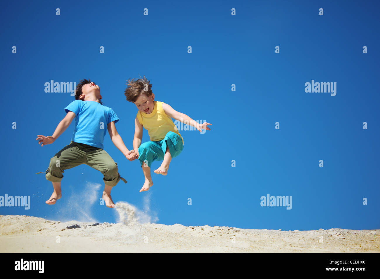 Two boys jump on sand Stock Photo Alamy