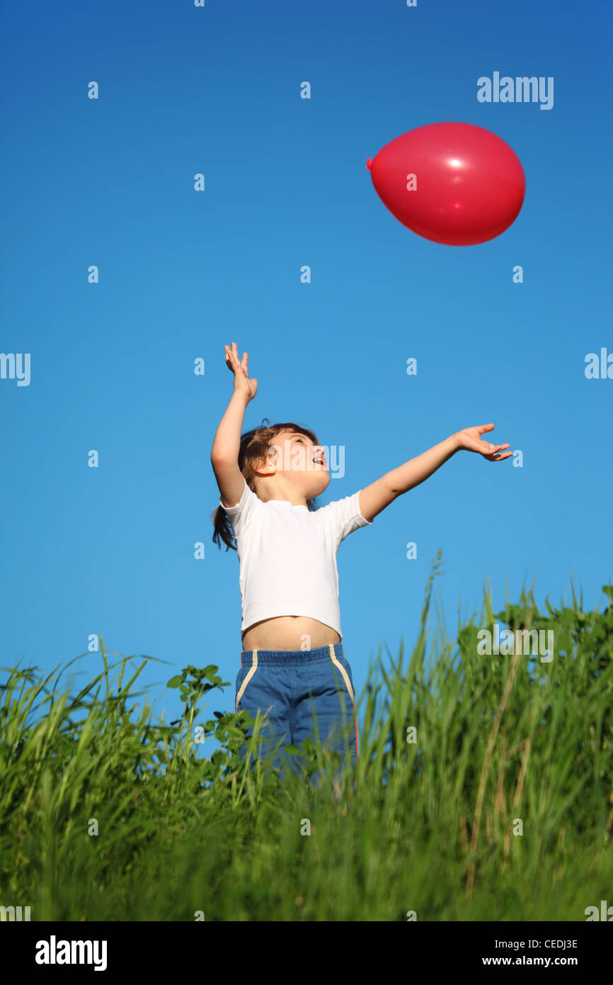 little girl plays with red balloon in grass Stock Photo - Alamy