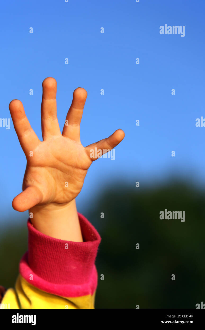 children's hand against sky Stock Photo