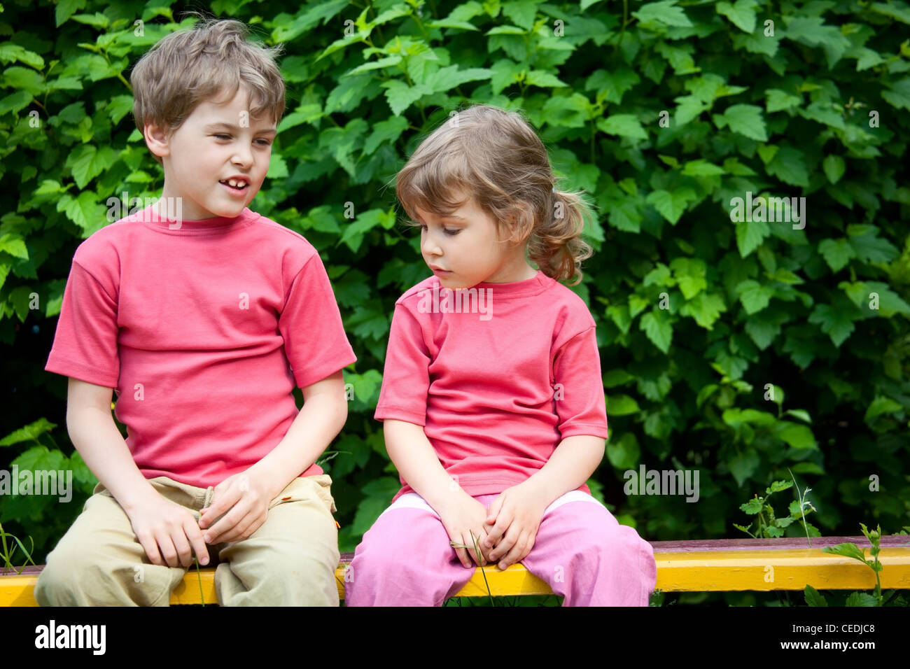 The boy and the girl sit on a bench in park Stock Photo - Alamy