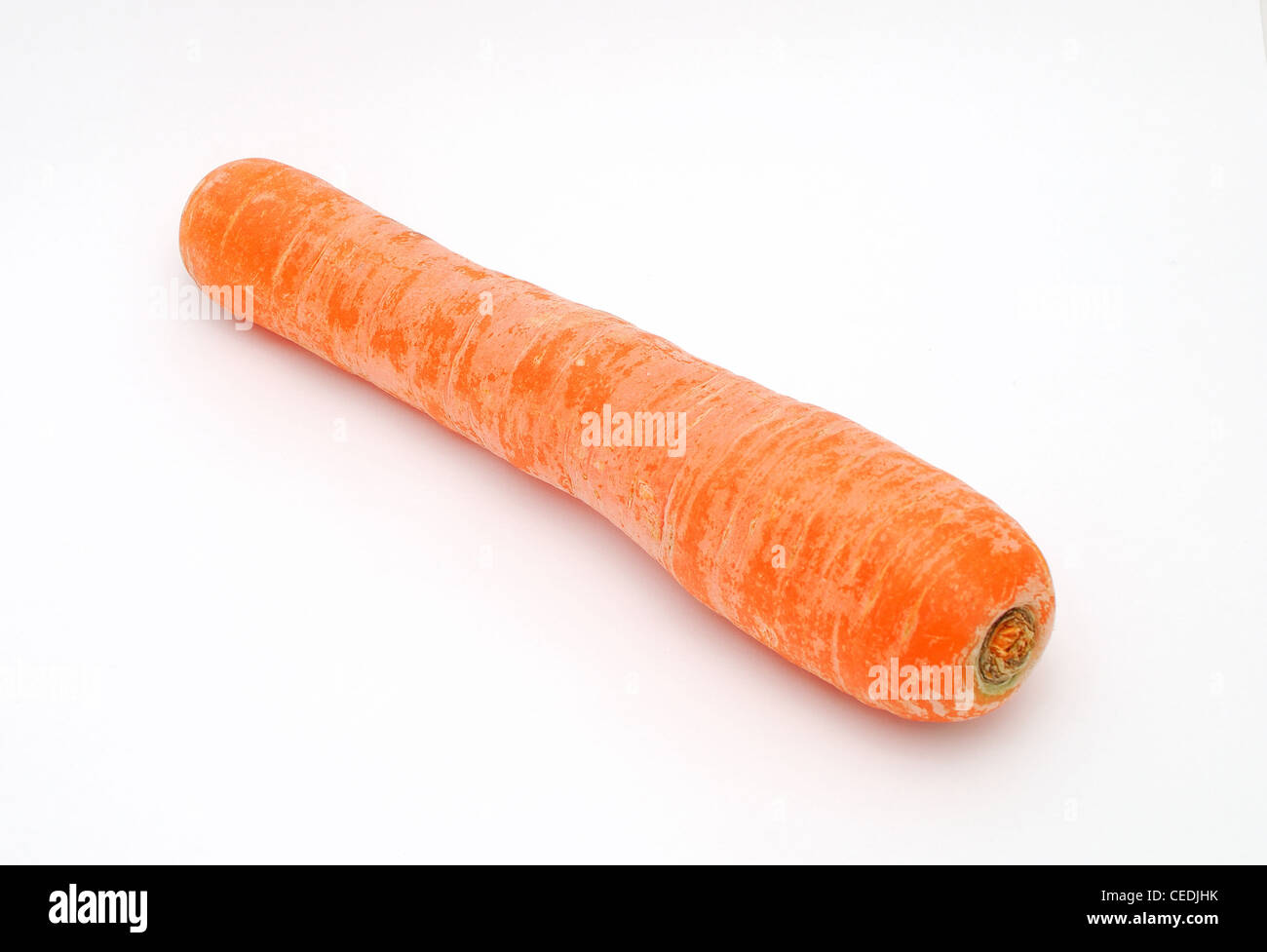 Detail image of one dirty carrot on the white background. Stock Photo