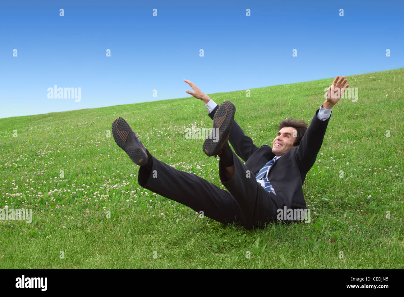 Businessman lying on the meadow Stock Photo
