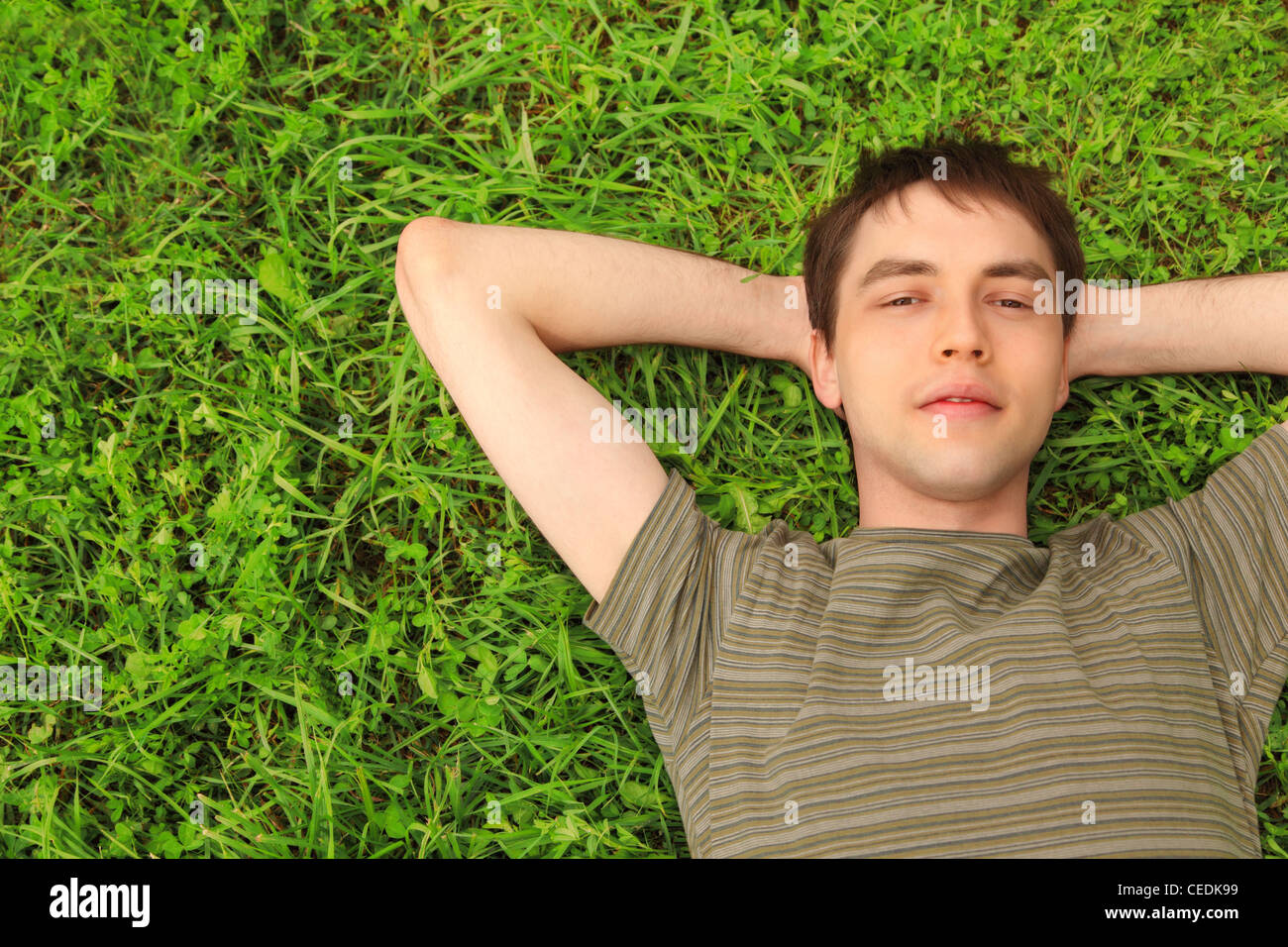 young man lies on grass Stock Photo Alamy