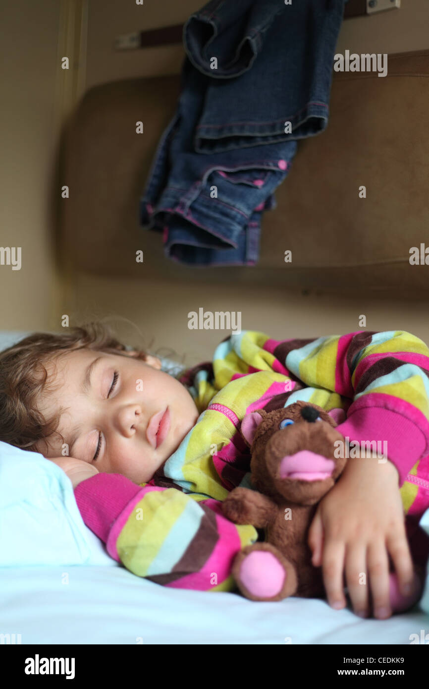 little girl sleeps in train with puppet Stock Photo