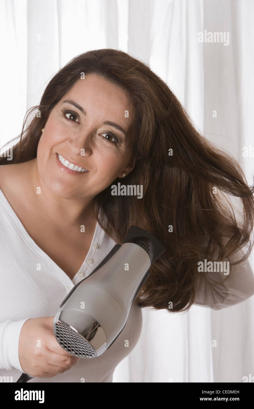 Hispanic woman drying her hair Stock Photo - Alamy