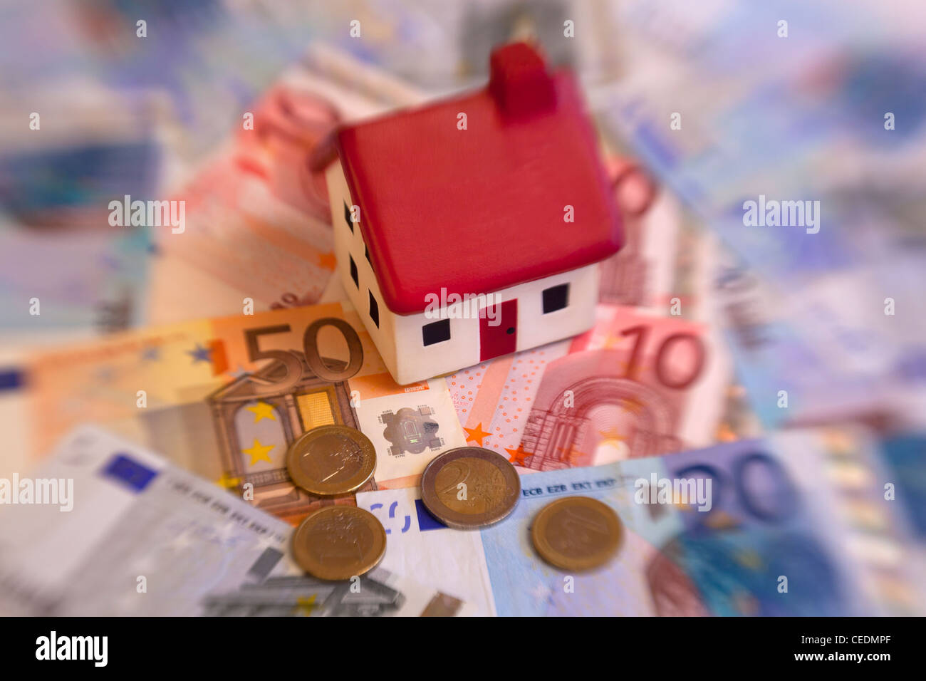 House on top of Euro coins and notes currency money Stock Photo