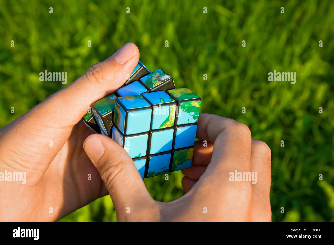 Cube in the manner of planets land in hand on background of the herb Stock Photo