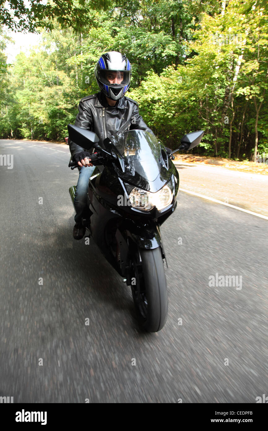 motorcyclist goes on road, front view Stock Photo