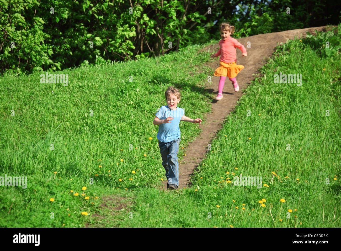 kids running down the hill Stock Photo