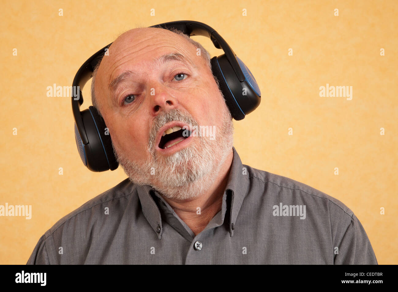 Elderly man with headphones, sings Stock Photo