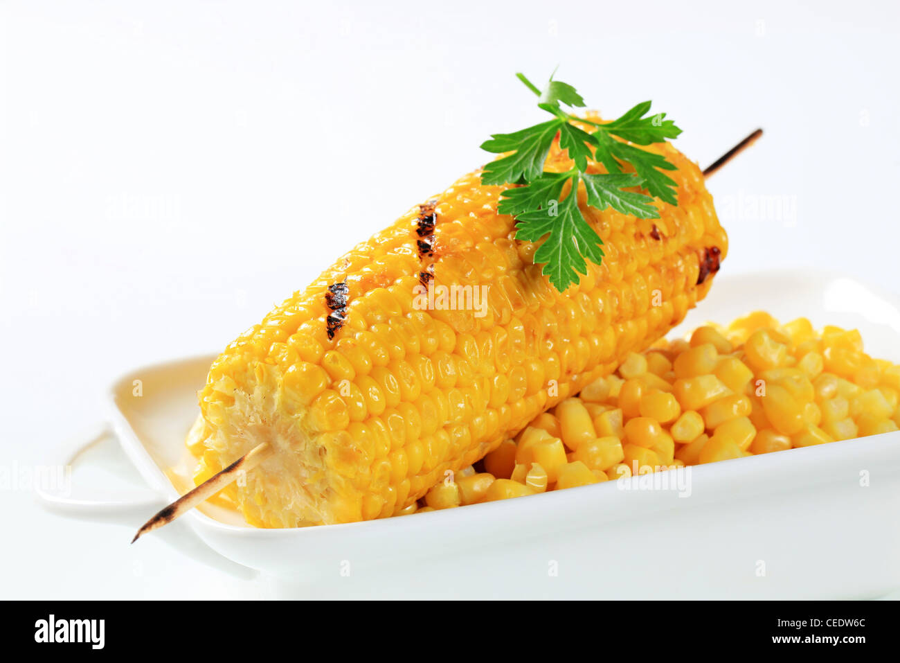 Sweet corn kernels and grilled corn on the cob Stock Photo