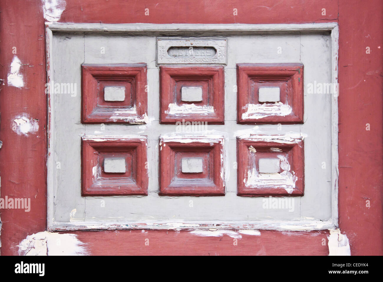 Detail of an vintage door how had a letters window and a white and red square decoration painted in red and white Stock Photo