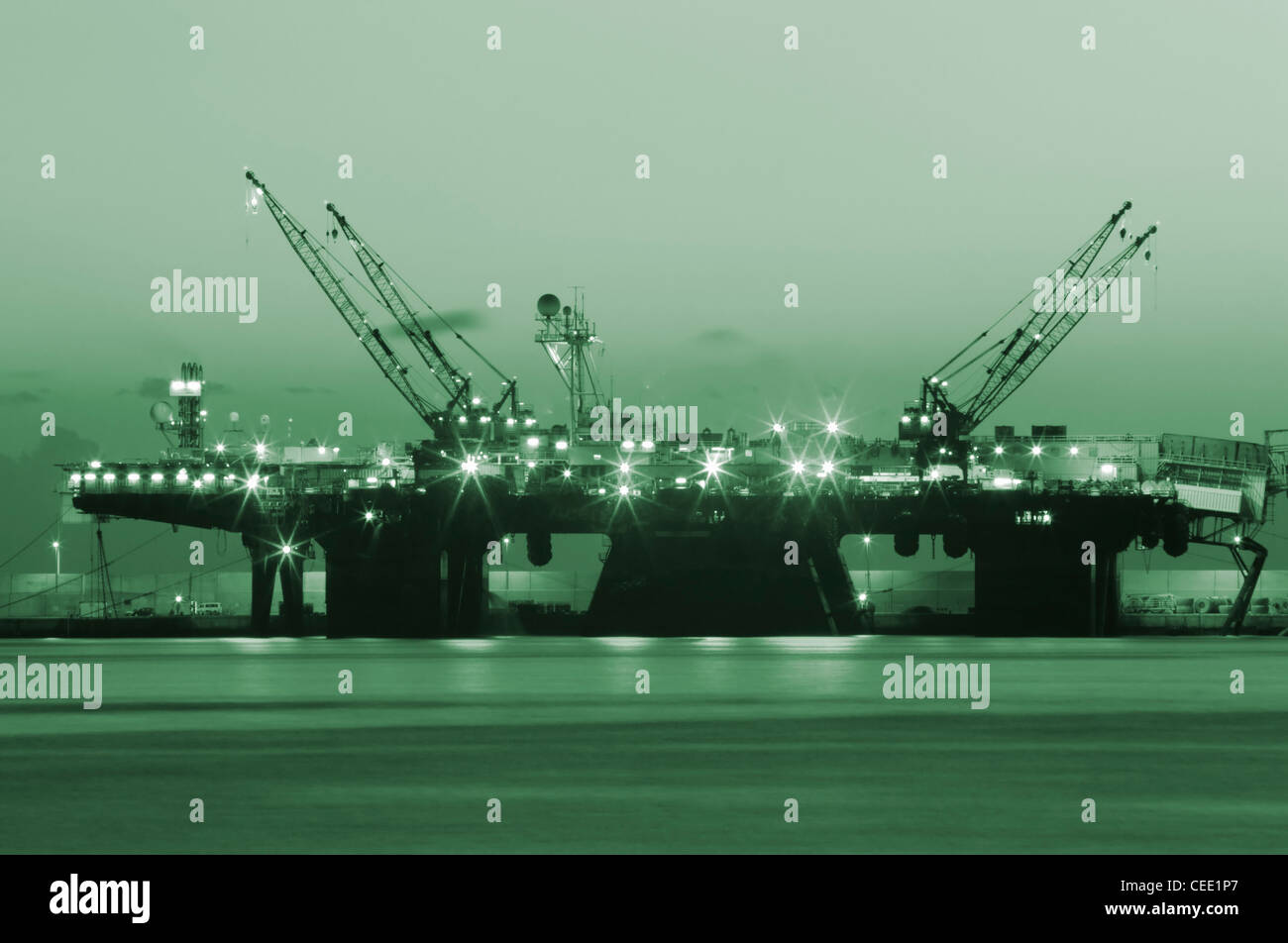 Oil rig at night. Green toned in Photoshop. Could be used to convey Green/clean fuel... Stock Photo