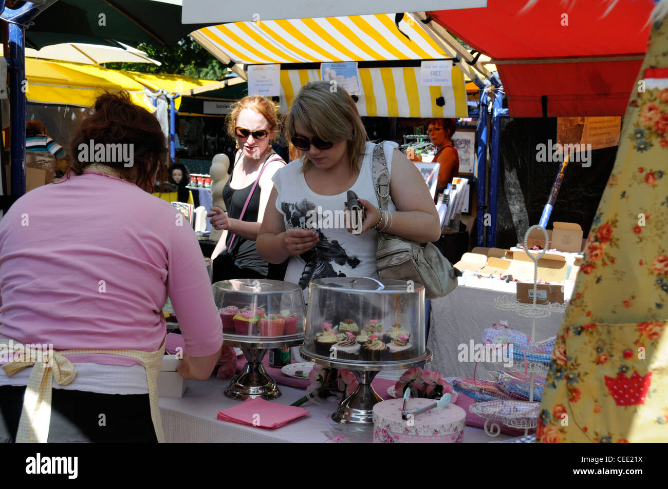 A shopper buying some home-made cakes at the  weekend market held in Worcester Street in Christchurch, New Zealand Stock Photo
