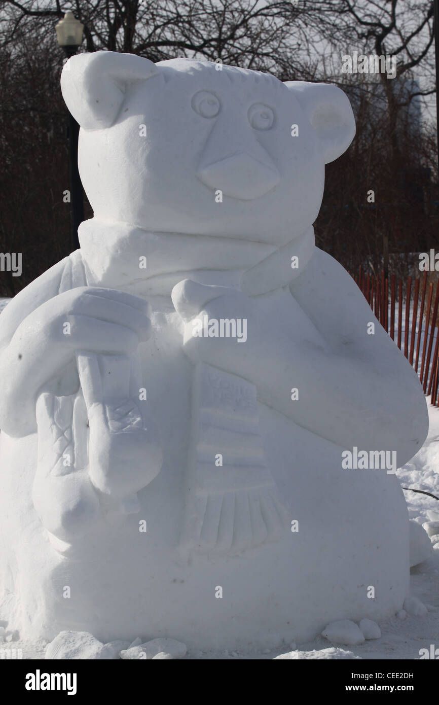 Snow sculpture of bear with skates over his shoulder Stock Photo