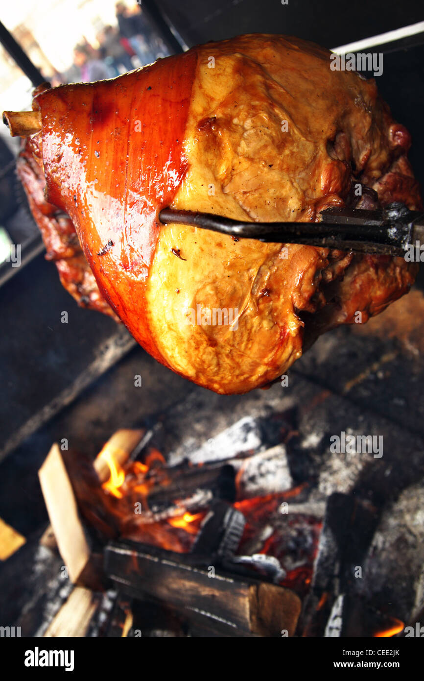 Grilled pig leg on spit close up Stock Photo