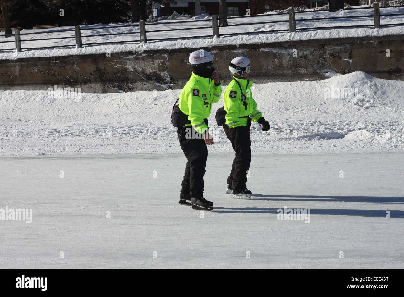Two skaters in reflective coats and white helmets Stock Photo