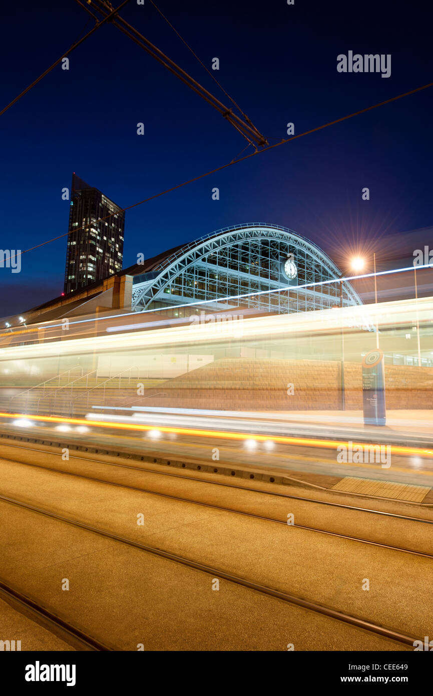 Light trails of a tram rushing past imprint themselves on a shot of Manchester Central GMex Centre. Stock Photo