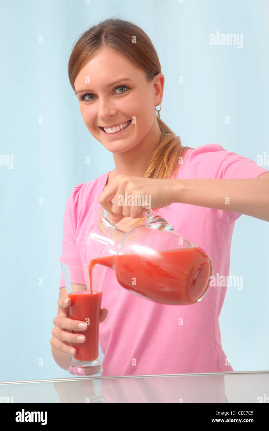 Young woman drinking tomato juice to detox. Stock Photo