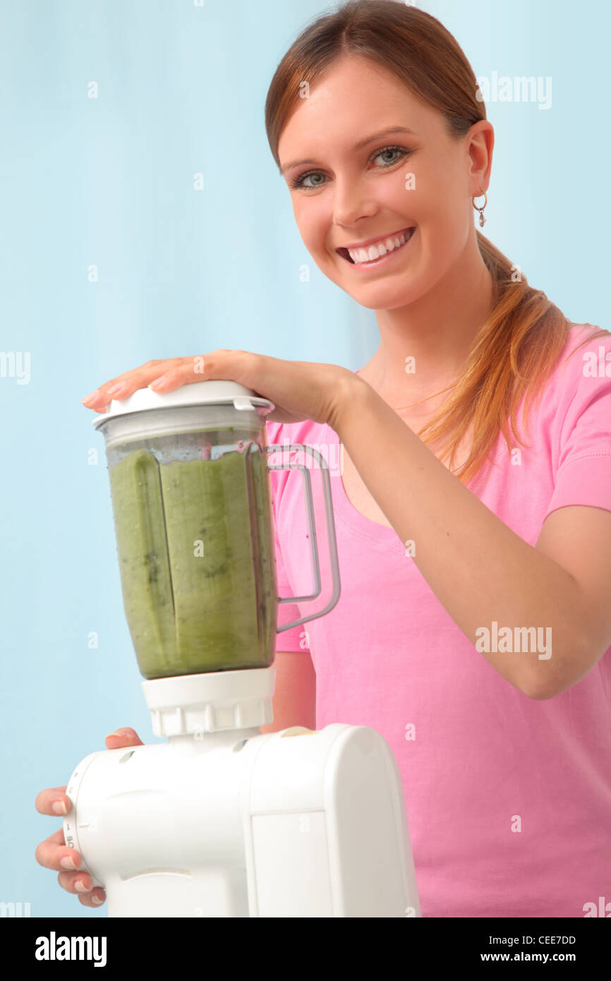 Young woman making parsley juice to detox. Stock Photo