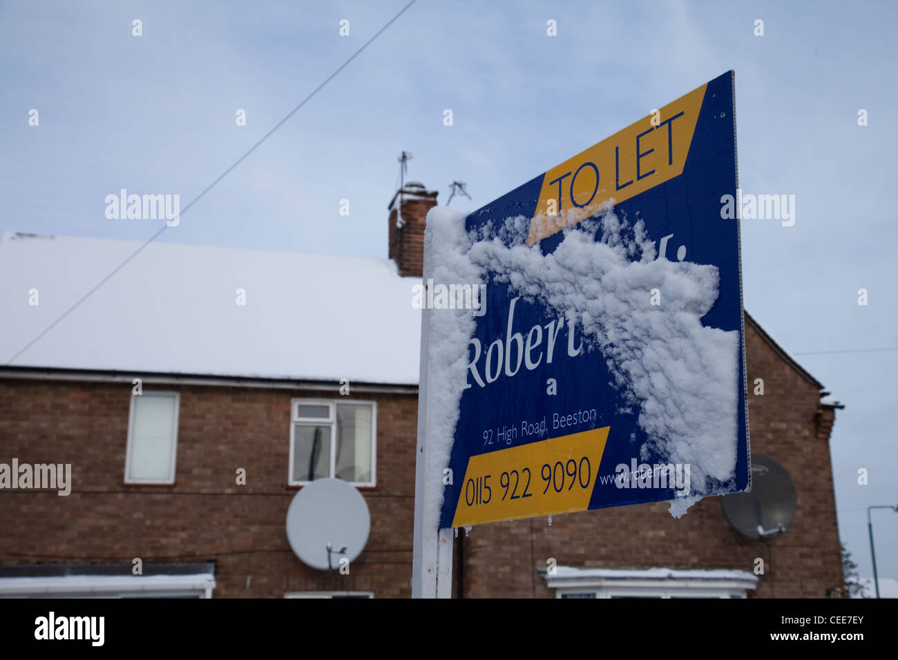 A house for sale sign covered in snow Nottingham England UK Stock Photo