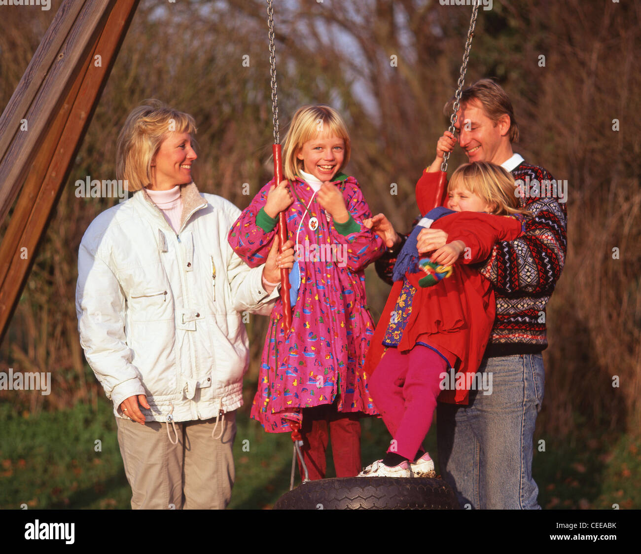 Young family at children's playground, in autumn, Berkshire, England, United Kingdom Stock Photo
