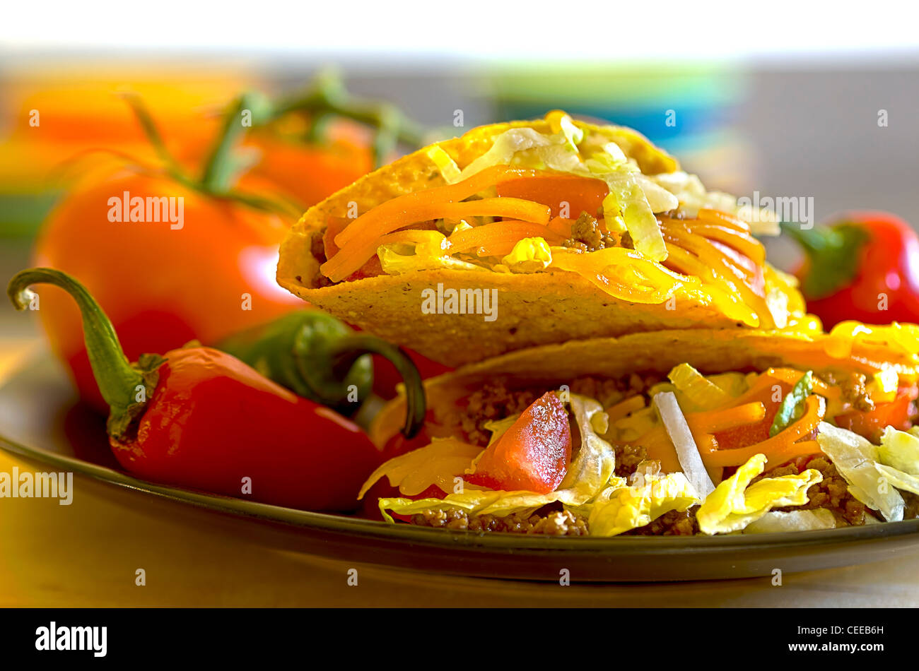 Tacos on plate with vine ripe tomatoes, red and green chili peppers. Stock Photo