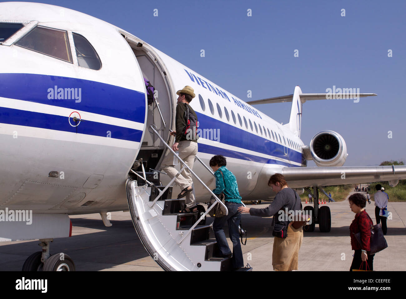 A Fokker 70 jet, part of the Vietnam Airlines fleet landed at Luang Prabang airport with passengers embarking Stock Photo