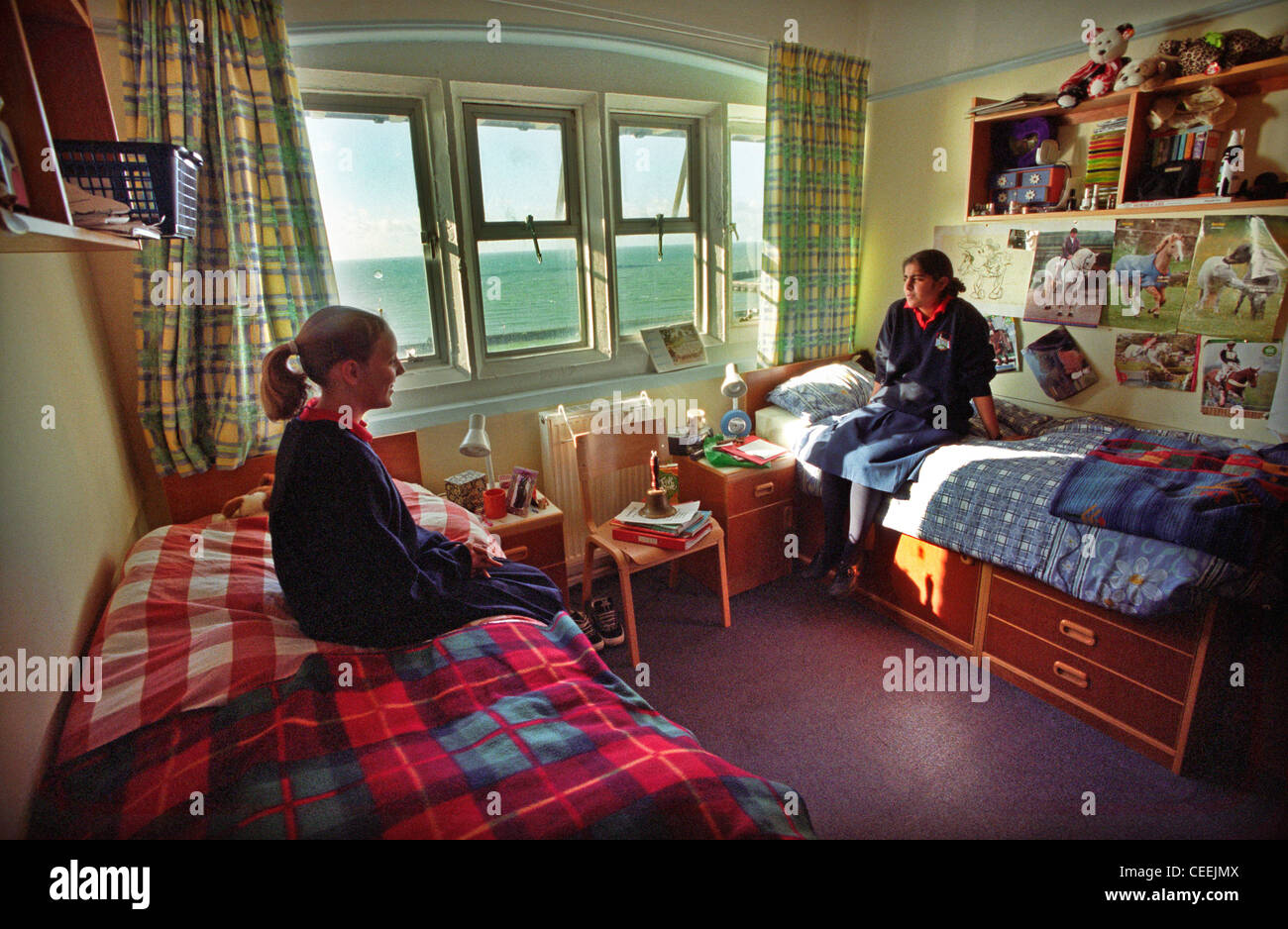 Two Roedean schoolgirl pupils chat in their boarding school dormitory bedroom Stock Photo
