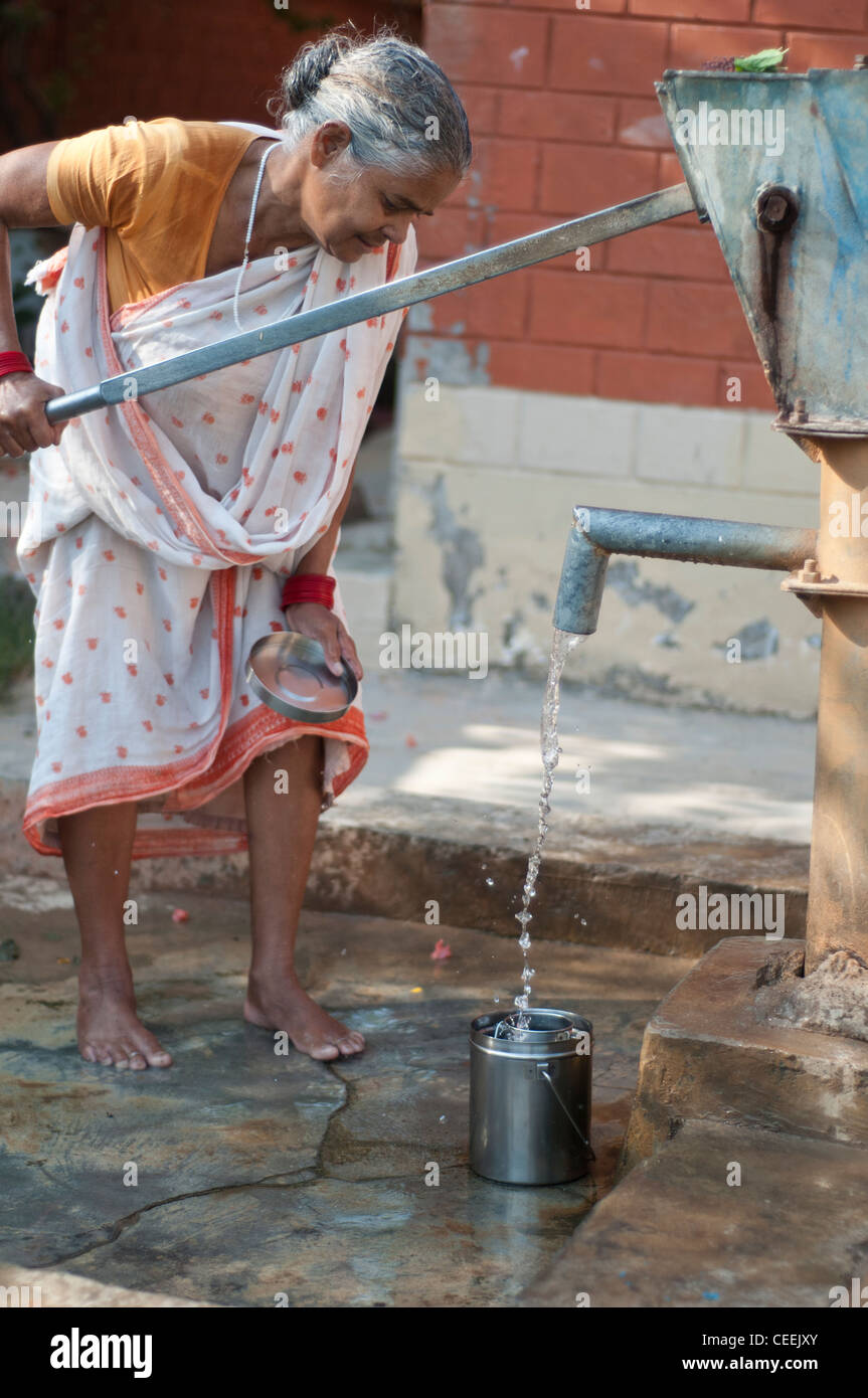 Widow pumping water, Ma Dham Ashram, run by NGO Guild of Service, Vrindavan, Uttar Pradesh, India Stock Photo