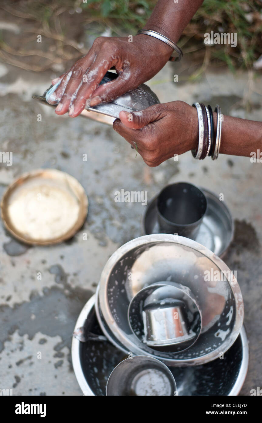 Widow cleaning dishes, Ma Dham Ashram, run by NGO Guild of Service, Vrindavan, Uttar Pradesh, India Stock Photo