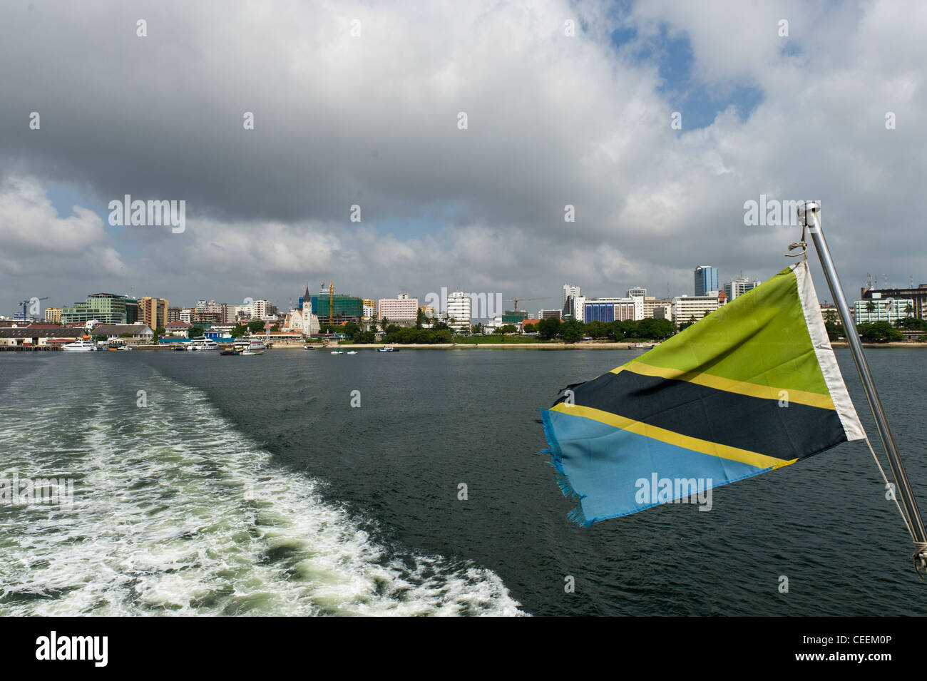 Harbor front of Dar es Salaam and Tanzanian flag on a ferry to Zanzibar Tanzania Stock Photo