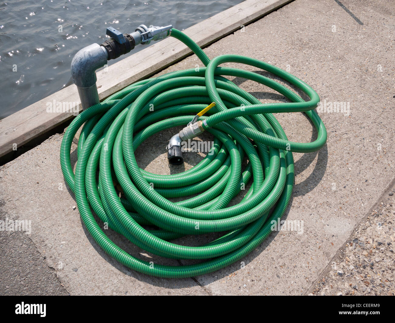 Coiled Green Water Hose Pipe for Supply to Boats Stock Photo - Alamy
