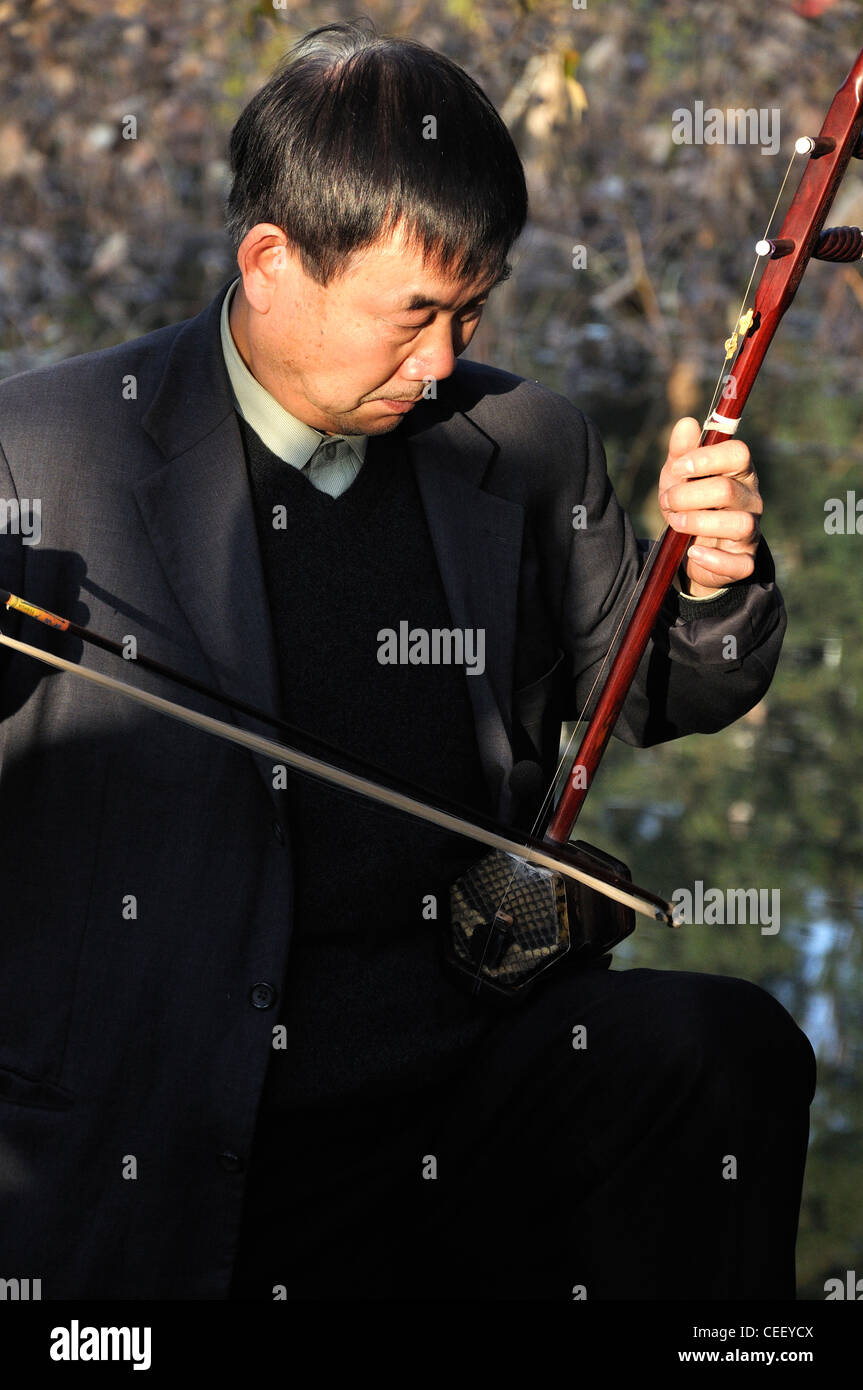 Chinese Erhu Player Beside Lake in Kunming Stock Photo