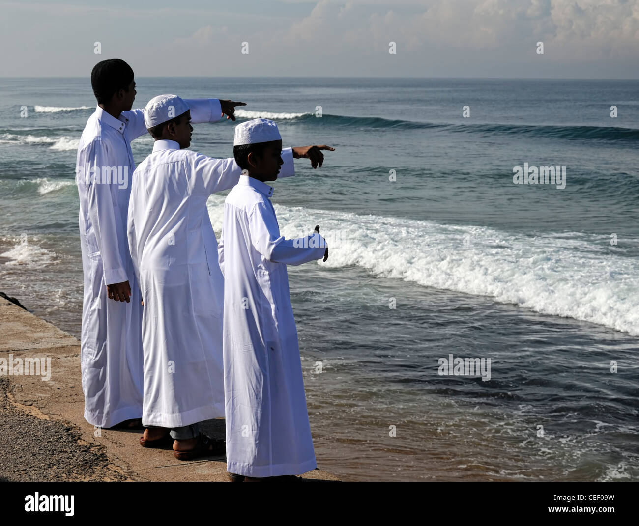 three-young-muslim-men-point-across-the-sea-towards-at-direction-mecca-CEF09W.jpg
