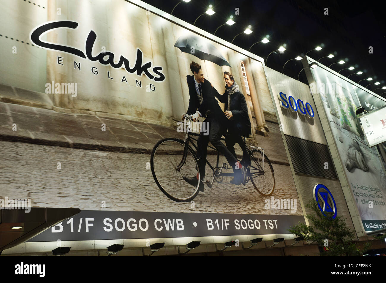 dh  CAUSEWAY BAY HONG KONG British firm Clarks shoes advert nighttime billboard bill board posters advertising advertisement Stock Photo