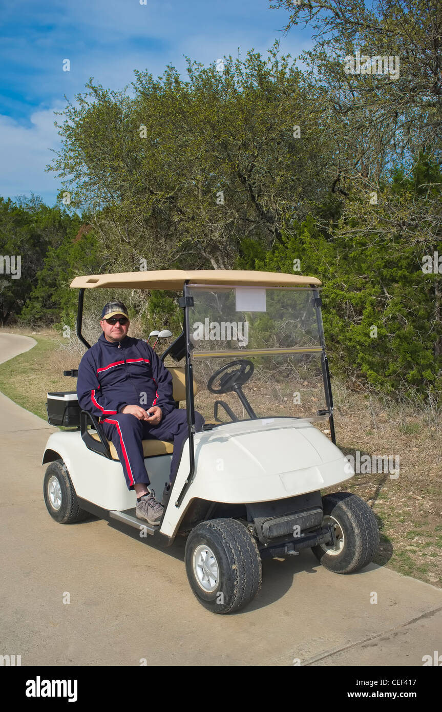 Man in sweat suit sitting in golf cart Stock Photo Alamy