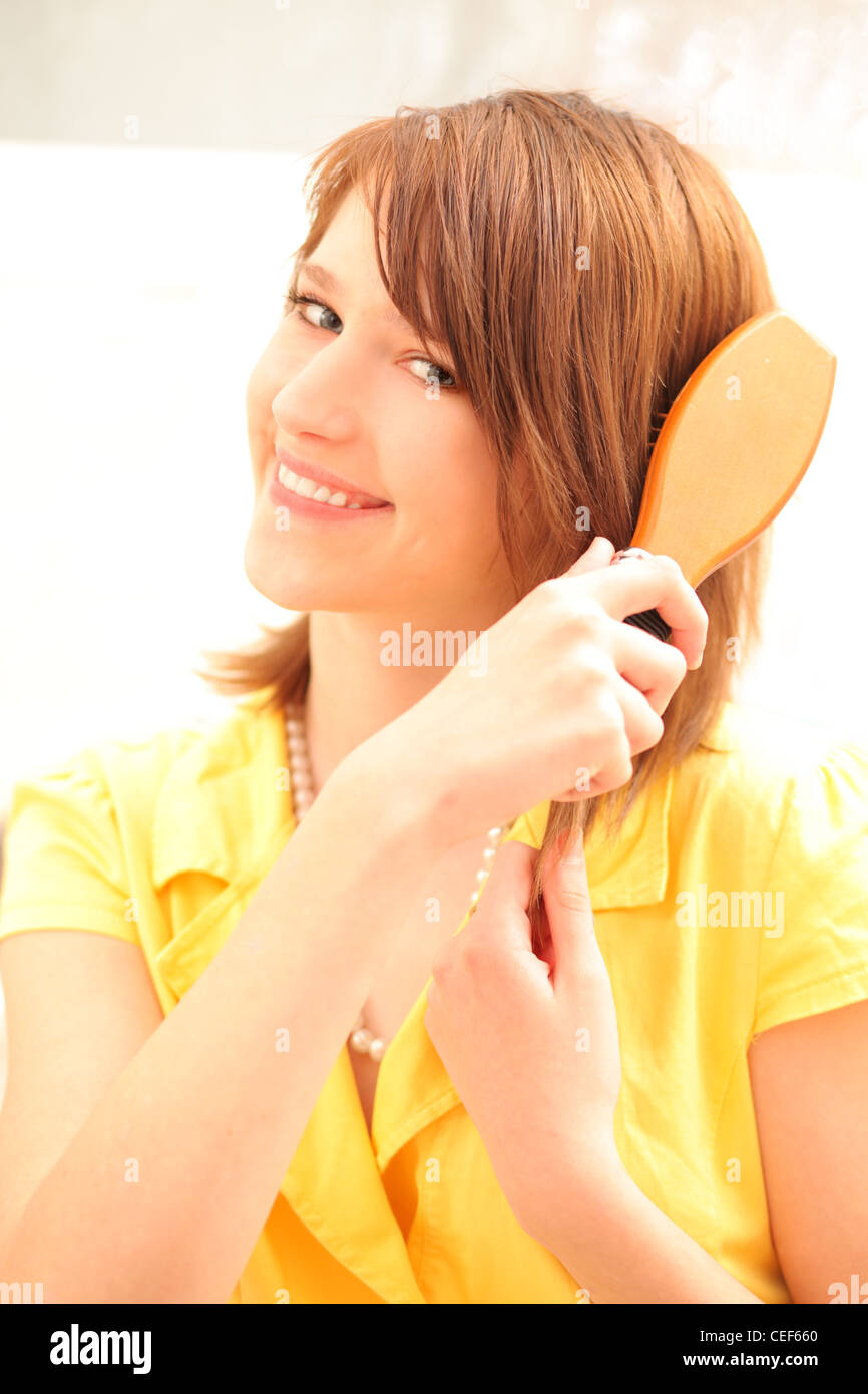 Teenager girl using hairbrush Stock Photo - Alamy