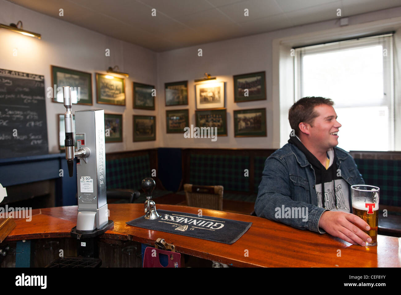 A man drinking a beer at the bar in a Scottish pub Stock Photo